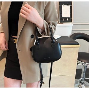 Classic black leather vintage handbag with metal clasp and detachable strap detail