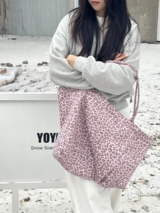Pink leopard print canvas tote bag with slim straps in an outdoor winter setting