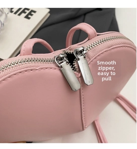 Dettaglio borsa a cuore rosa con doppie cerniere in metallo argentato a scorrimento