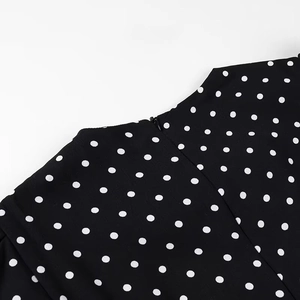Detail of invisible zipper and white polka dots on black vintage retro style dress