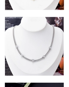 Macro detail of silver heart necklace with pavé crystal charms on Cuban chain