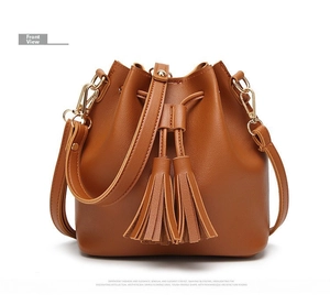 Detail of retro brown PU leather bucket bag featuring fringe tassels and drawstring