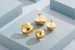 Detailed view of gold heart and semi-circle earrings set on a geometric display