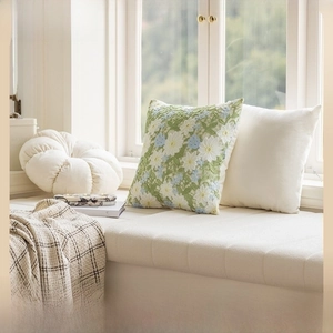 Detailed close-up of premium beige floral embroidery on luxury cushion covers