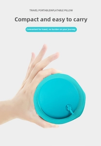 Compact folded cyan travel pillow held in hand showing portability and premium fabric