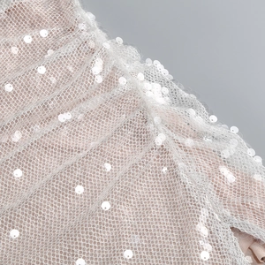 Makroaufnahme von Silberpailletten auf transparentem Netzstoff eines Abendkleids
