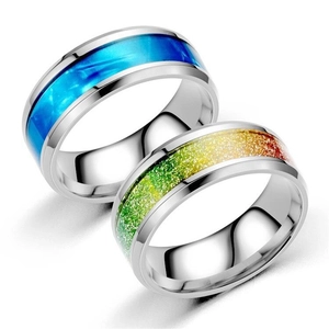 Polierte Edelstahlringe mit blauer Marmorierung und Regenbogen-Glitzereinlage auf weißem Grund