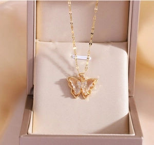 Macro shot of 18k gold plated butterfly pendant necklace with crystal inlay in jewelry box