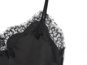 Dettaglio del top in raso nero con bordo in pizzo e spalline sottili regolate