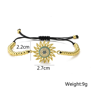 Detail view of 18K gold plated sunflower charm with blue and white zircon inlays