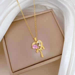 Luxurious gold-plated heart pendant necklace with pink crystal on elegant silk background