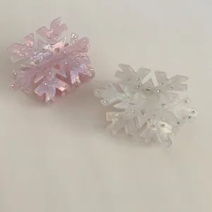Elegant snowflake hair claws in pink and pearl white acetate with sparkling rhinestones