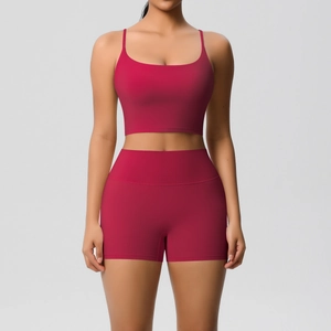 Front view of a dark red two-piece yoga set featuring a strappy sports bra and high-waisted shorts