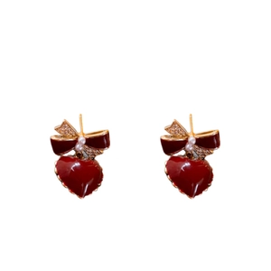 Elegant red heart drop earrings with gold bows, pearls and crystals on white background