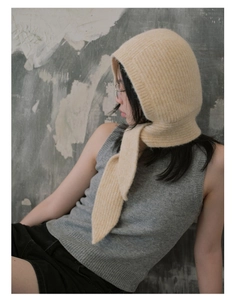 Detail showing soft knit floral ear protection hat with light yellow texture and strap
