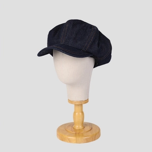 Gros plan d'une casquette gavroche en denim bleu foncé avec coutures classiques