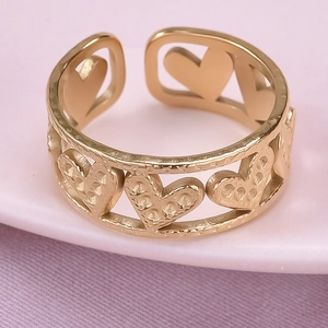 Macro view of gold stainless steel ring with hollow hearts and hammered texture detail
