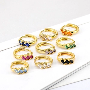 Macro detail of nine vibrant baguette-cut zircon huggie earrings in diverse colors