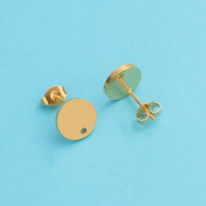 Detail of round flat-pad gold stud earrings with small hole and butterfly backs