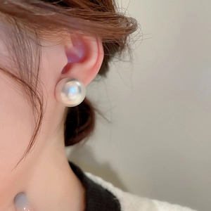 Elegant large white pearl stud earring shown on model with natural glossy finish and luster