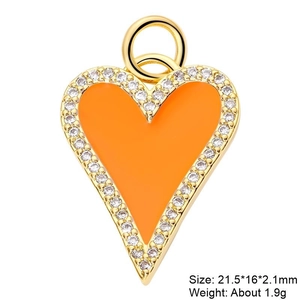 Detail of orange enamel heart pendant with gold edging and zircon stone inlay