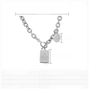 Dettaglio macro della collana in acciaio inossidabile argento con chiusura OT e ciondoli