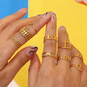 Detailed view of stacked 18K gold plated stainless steel rings in geometric and heart designs