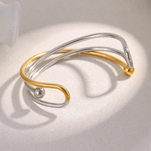Détail du bracelet jonc ouvert multicouche en plaqué or 18K et argent au style épuré