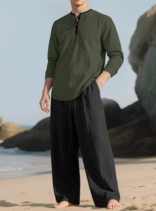 Detail of olive green linen shirt with black drawstring beach pants in outdoor sun