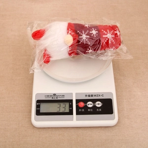 Detailed scale view of a glowing Christmas gnome plush showing its light weight of 33g