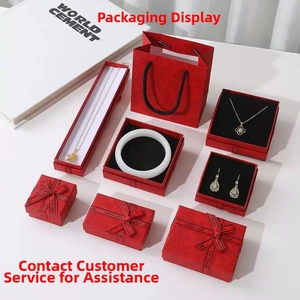 Detalle de cajas de regalo rojas para joyas con cintas doradas y bolsas a juego premium