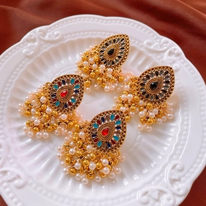 Detail of vintage style fringe earrings with colorful gemstones and pearl beads tassels