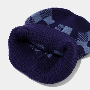 Detailed knit texture of checkerboard beanie hat with ribbed cuff for winter warmth