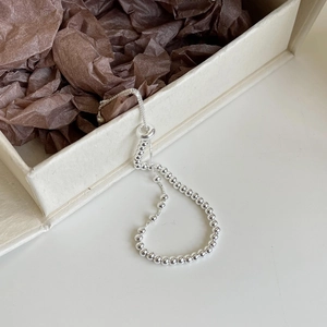 Detail of adjustable S925 silver beaded bracelet over a jewelry box with sliding clasp