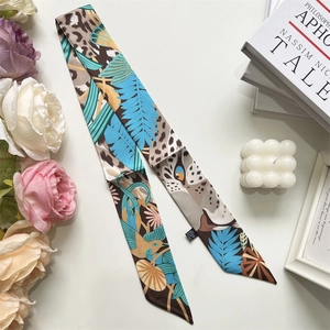 Detail view of long silk scarf with jungle animal prints on a decorative background