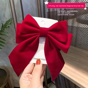 Detail of a large 14.5cm red velvet bow hair clip showing size dimensions and fabric texture