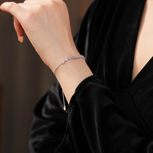Macro detail of silver clover bracelet featuring sparkling zircons and adjustable clasp