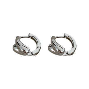 Minimalist silver twist hoop earrings with a fluid wave design on white background