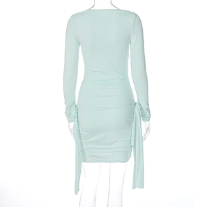 Détails d'une robe vert menthe à manches longues avec plis au dos et lacets latéraux