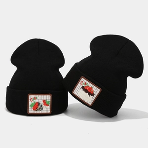 Black knit beanie with strawberry cake embroidery shown from front and side angles