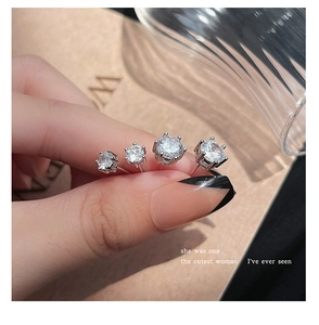 Macro view of four different sizes of silver six-prong cubic zirconia stud earrings