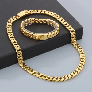 Golden 12mm Cuban link chain necklace and bracelet set in a professional jewelry display