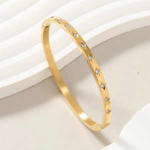 Close-up of star-set zircons on a gold-plated stainless steel bangle with polished finish