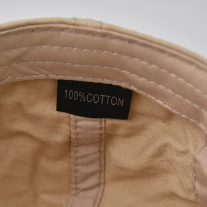 Detail view of cotton beret showing 100% cotton label and fine stitching quality