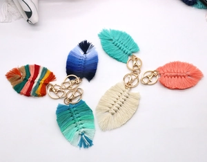 Macro detail of leaf-shaped macrame keychain with cotton fiber texture and gold lobster clasp