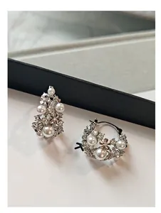 Detailed macro view of silver floral basket earrings with pearls and sparkling zircons