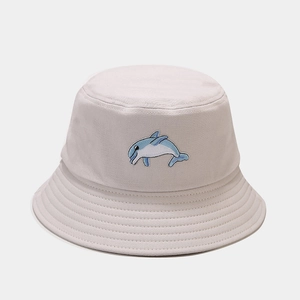 Gros plan du bob en toile gris clair avec les détails d'une broderie dauphin bleu