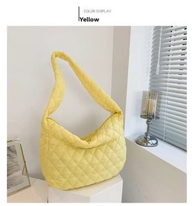 Detail of yellow quilted tote bag showing large diamond stitching and nylon texture