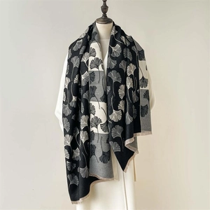 Detailed close-up of thick winter scarf with ginkgo leaf pattern and elegant fringe