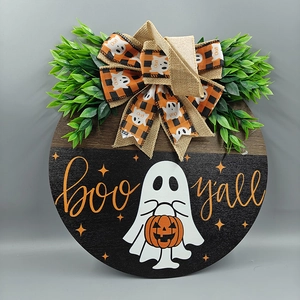 Detail of wooden Halloween door sign with Boo y'all text, burlap bow and faux greenery